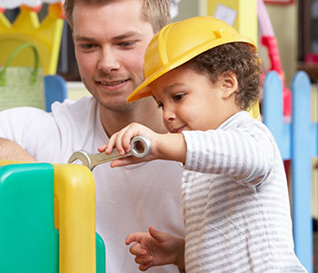 child showing motor skills by using play tools with a man, cerebral palsy treatment